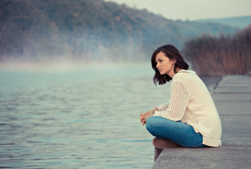 Das Mädchen sitzt am See