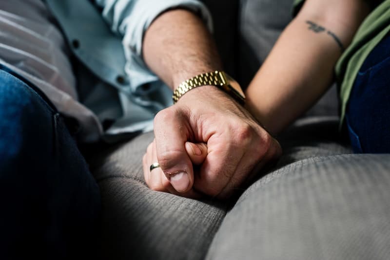Nahaufnahmefoto des Mannes, der Frauenhand im Auto hält