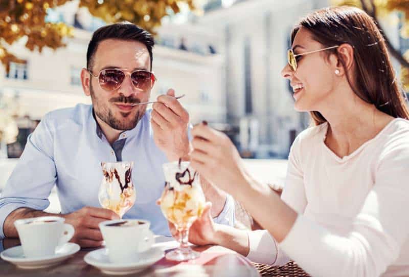 glücklicher Mann und Frau, die Eis im Café essen