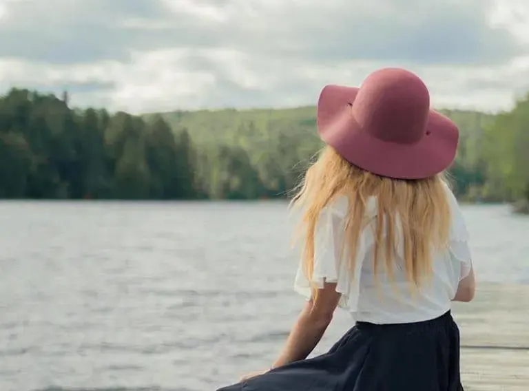 Frau mit Hut am See