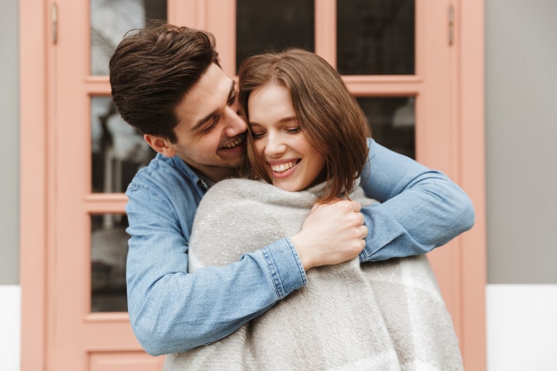 Ein verliebtes junges Paar steht draußen und umarmt sich