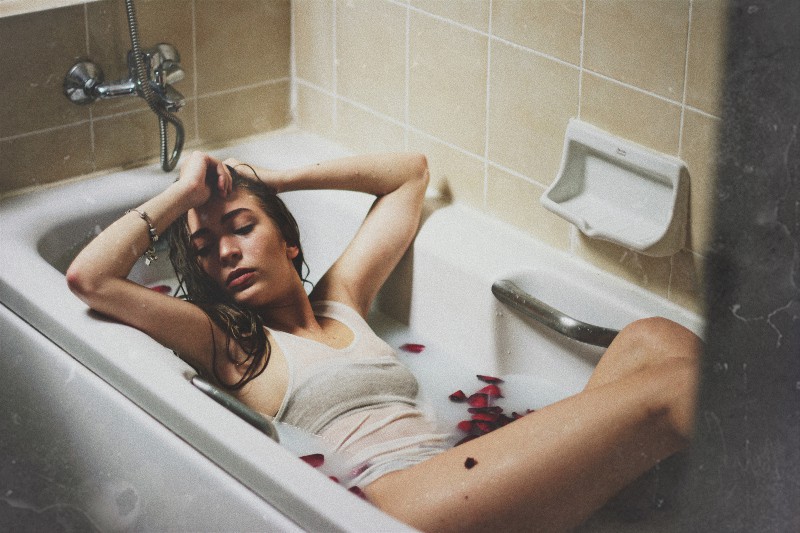 Frau liegt auf Badewanne