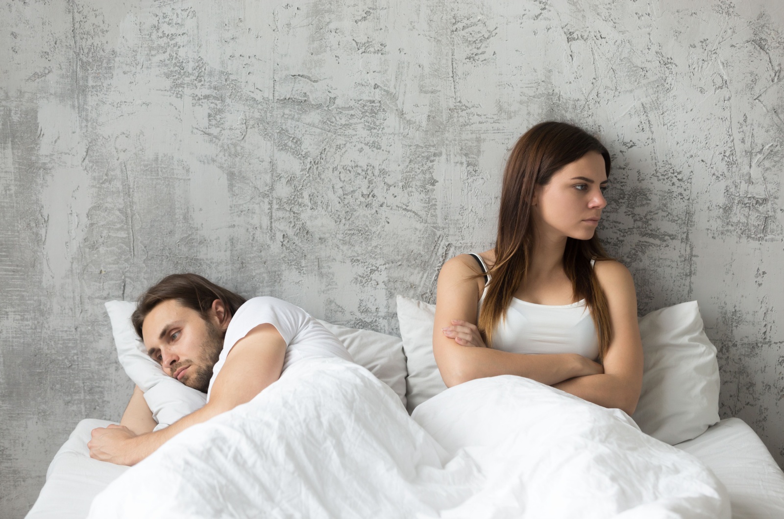 Paar im Bett ignoriert sich gegenseitig