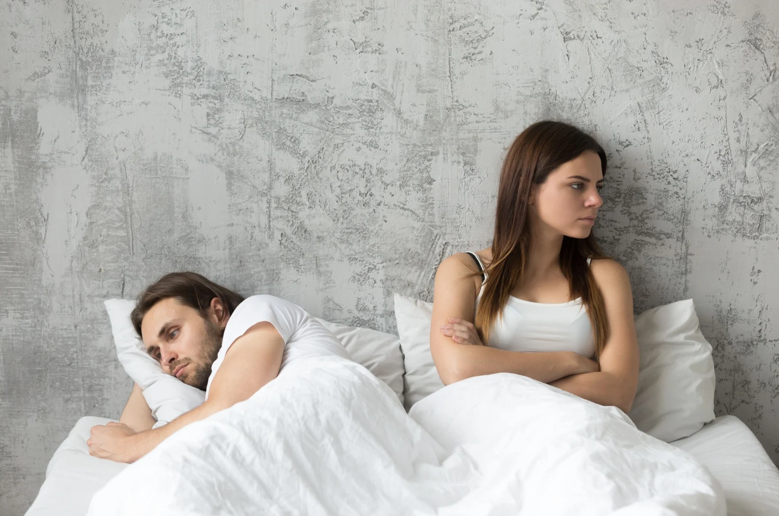 Paar im Bett ignoriert sich gegenseitig