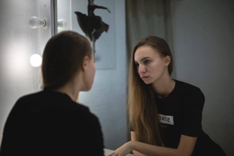 ein Mädchen, das in den Spiegel schaut