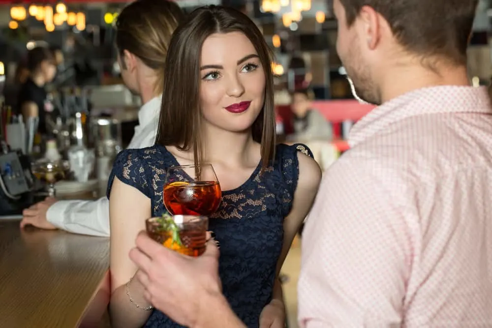 Ein Mann und eine Frau flirten an einer Bar