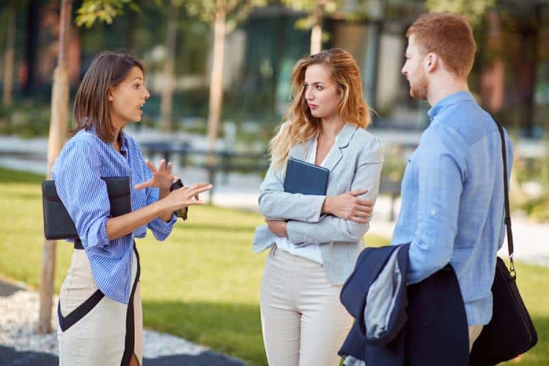 Eine Frau erklärt und gestikuliert ihren Kollegen, Geschäftspartnern