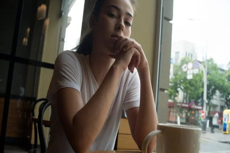 Eine traurige Frau sitzt in einem Café und denkt nach