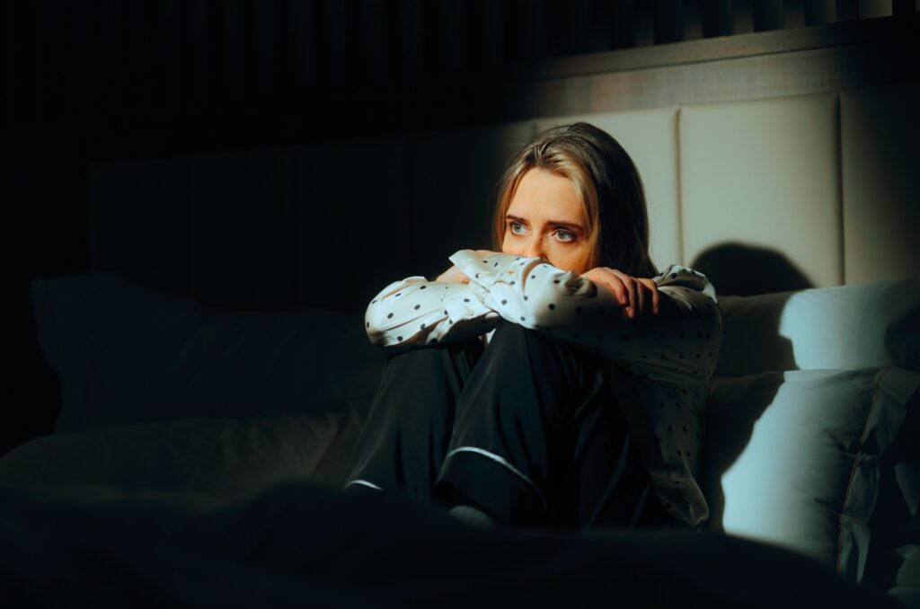 Frau sitzt auf dem Bett