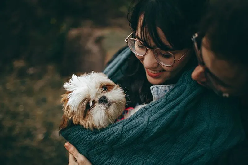 Mann und Frau mit niedlichem Hund im Arm