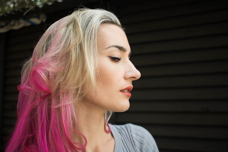 Porträt einer Blondine mit rosa Strängen