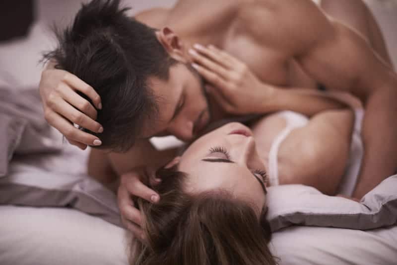 romantisches Paar küsst sich auf dem Bett