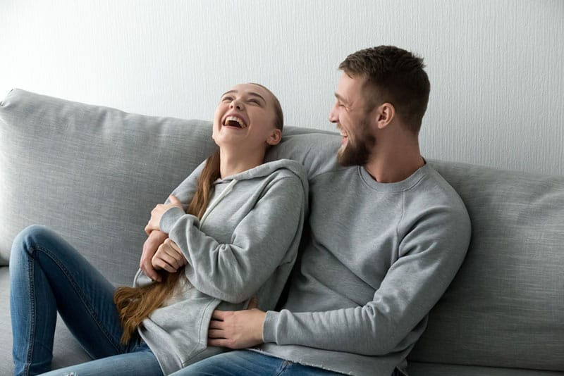 schönes Paar lacht im Wohnzimmer