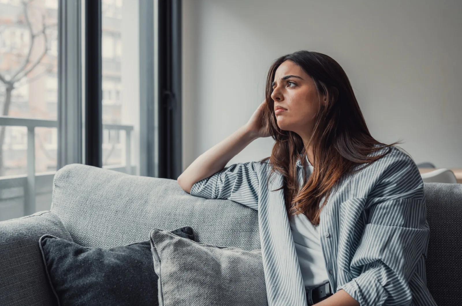 traurige Frau sitzt auf der Couch