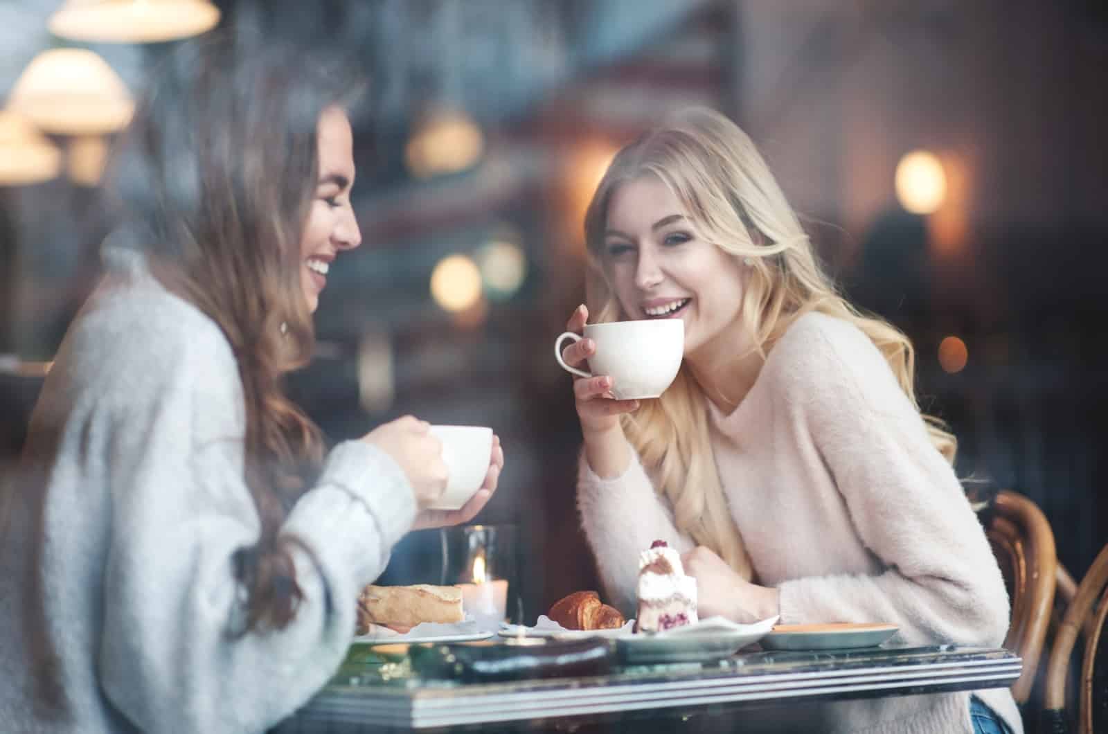 zwei glückliche Frauen, die Kaffee trinken