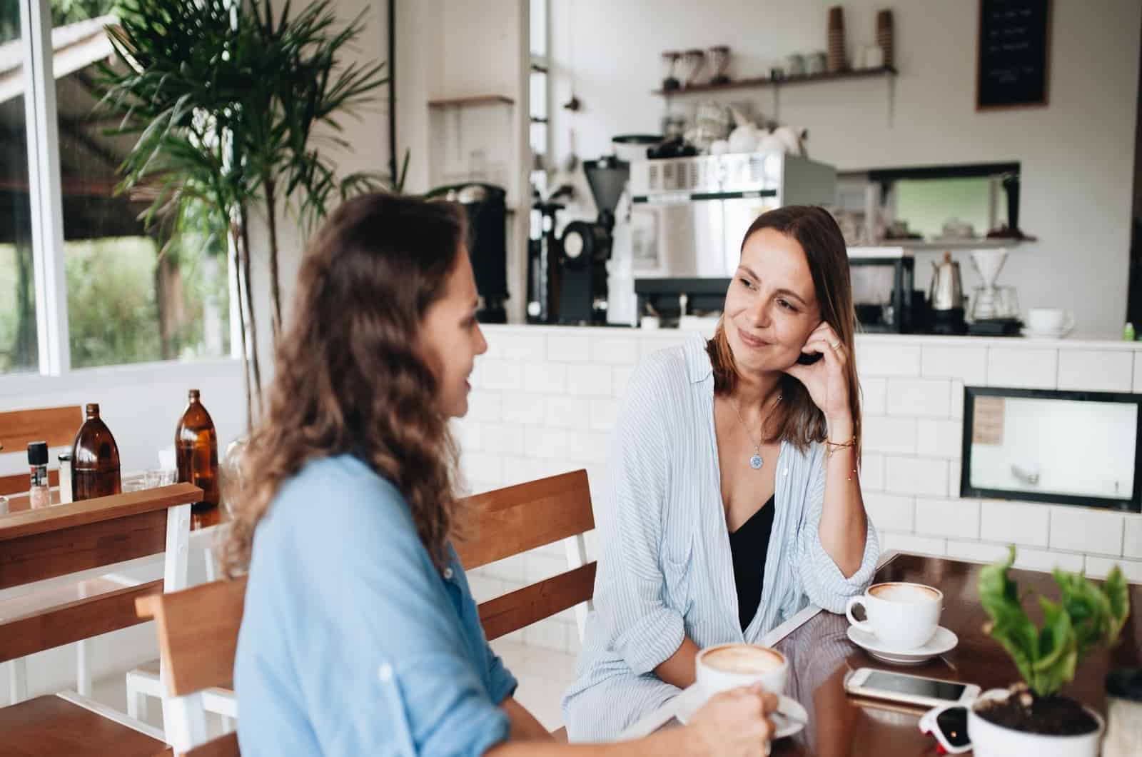 zwei junge Frauen unterhalten sich im Café