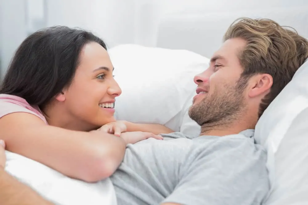 Ein Mann mit Bart und seine Frau unterhalten sich im Bett