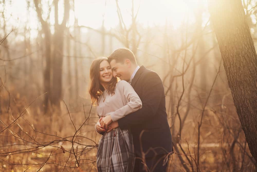 Ein Mann und eine Frau umarmen sich im Wald