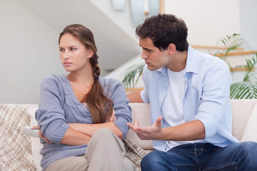 Ein wütender Mann überzeugt seine Frau, als sie auf dem Sofa sitzen