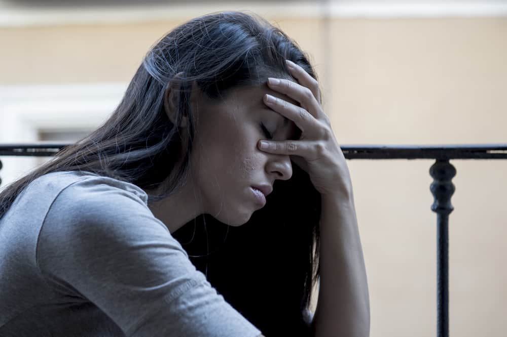 Eine gedemütigte Frau wird hinter ihrem Kopf gehalten