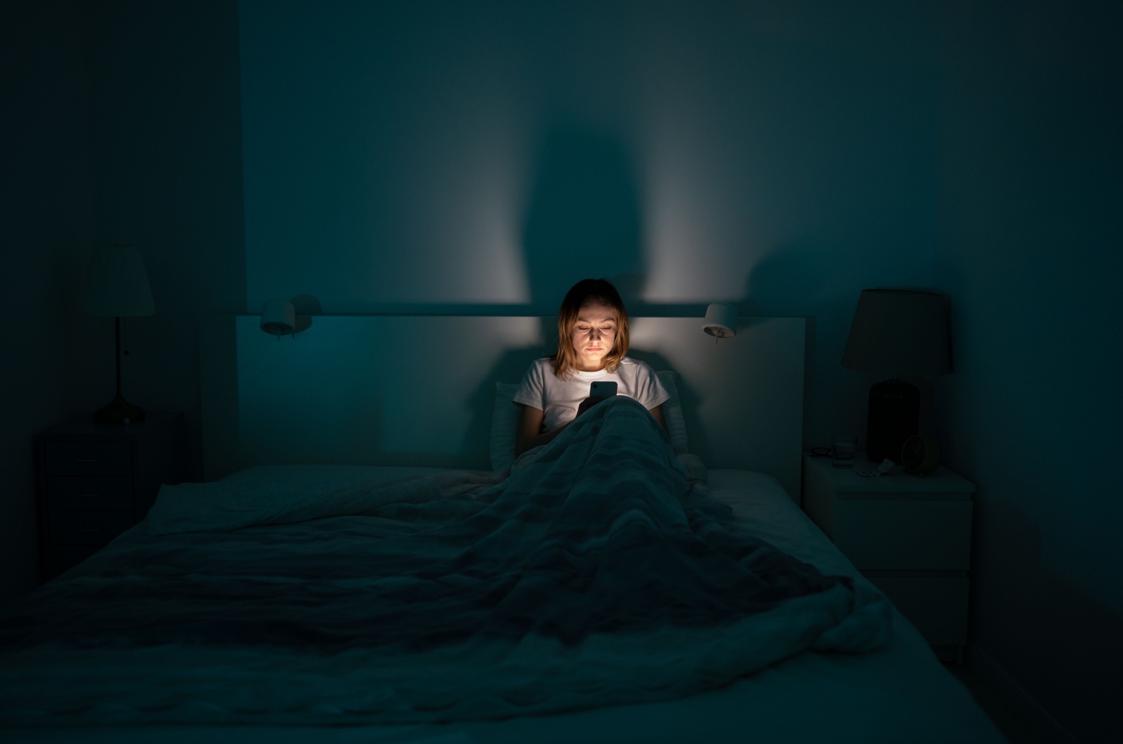 Frau im Bett mit einem Telefon