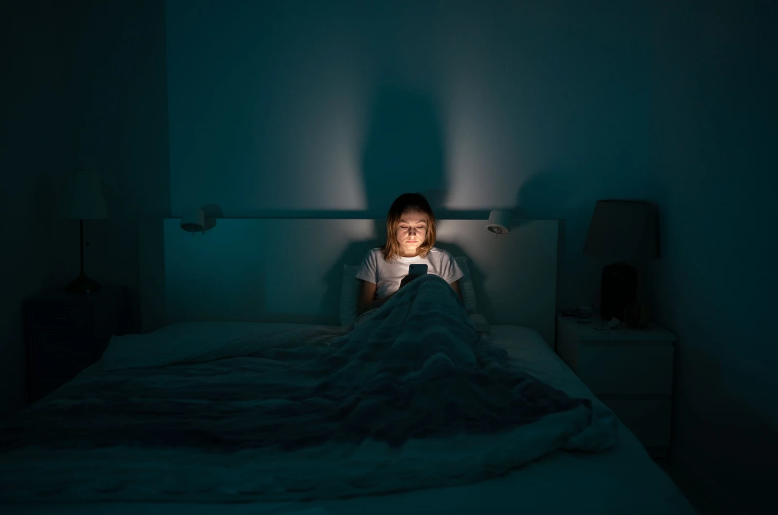 Frau im Bett mit einem Telefon