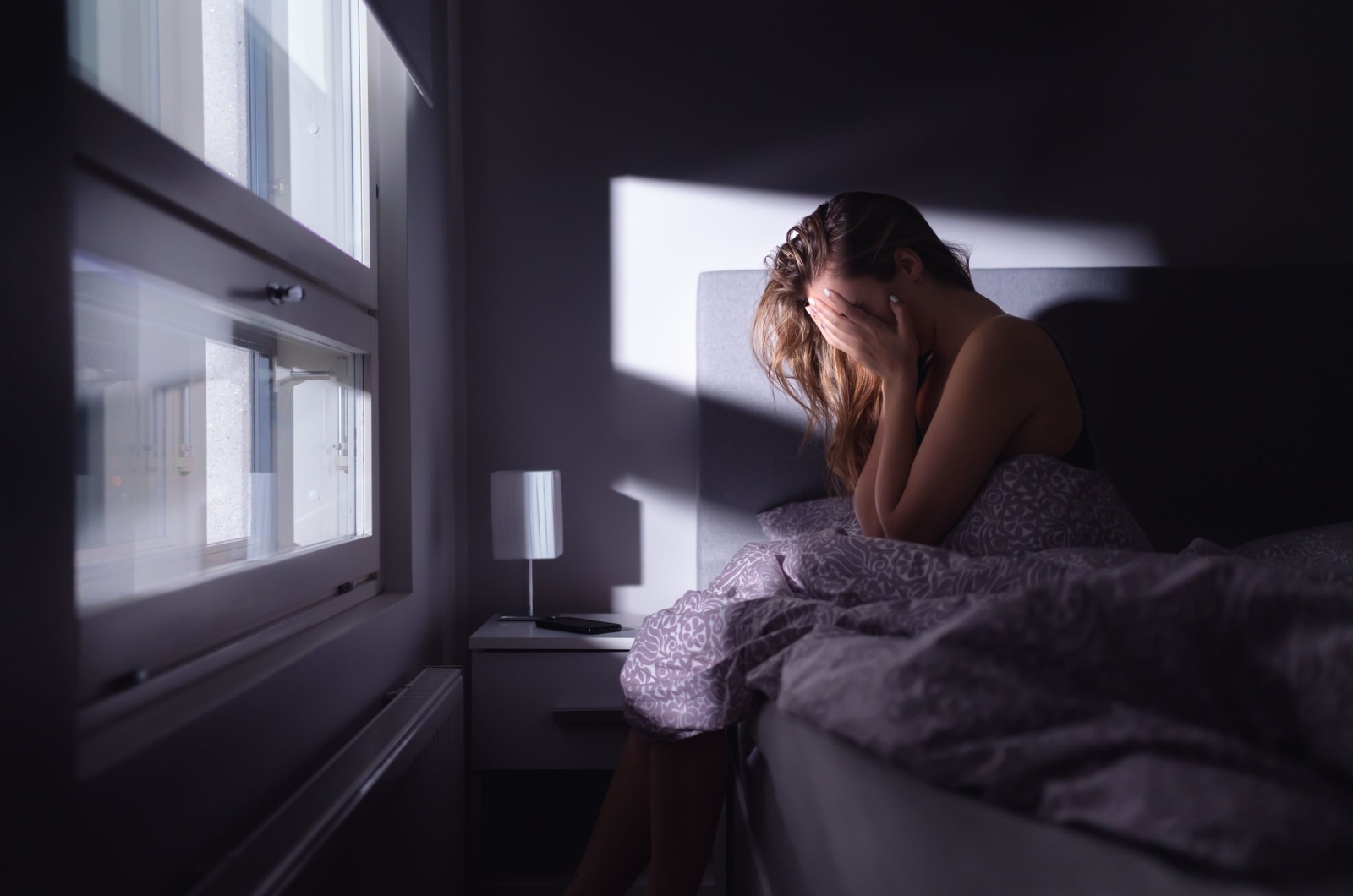 Frau weint im Bett