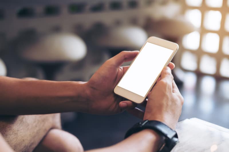 ein Mann, der ein Handy in den Händen hält(1)