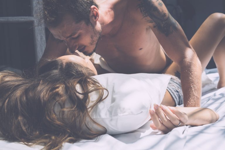 Ein Mann, der mit einem Mädchen im Bett liegt und Liebe macht