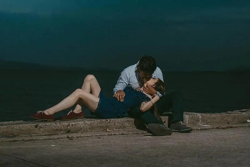 Mann küsst Frau, während er sich auf seine Beine stützt