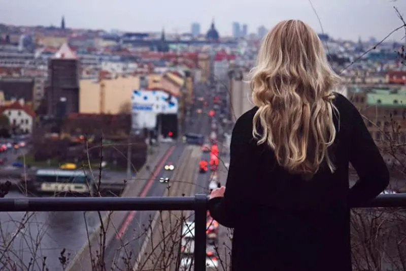 Ein blondes Mädchen beobachtet die Stadt aus großer Höhe