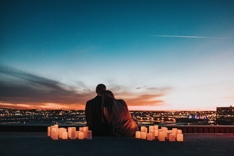 Das Paar sitzt auf einem von Kerzen umgebenen Gebäude