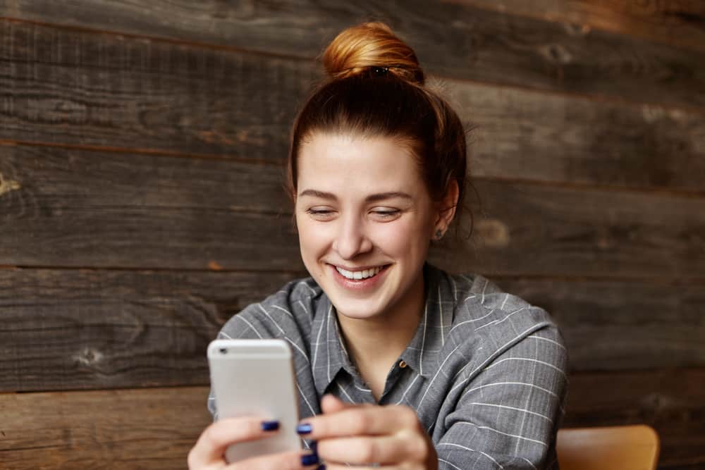 Eine glückliche Frau liest eine Nachricht auf ihrem Handy