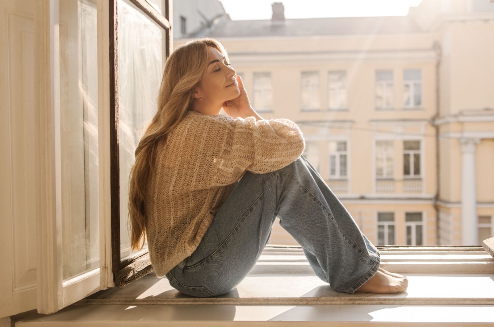 Frau sitzt am Fenster