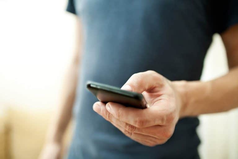 ein Mann, der ein Handy in den Händen hält