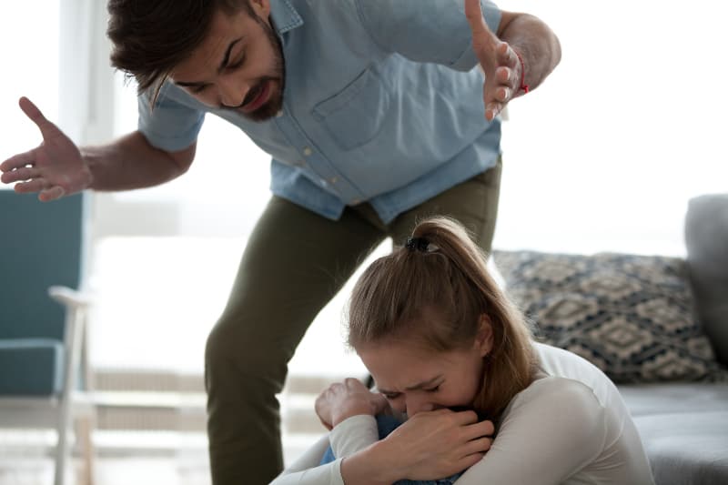 ein Mann, der eine unglückliche weinende Frau anschreit
