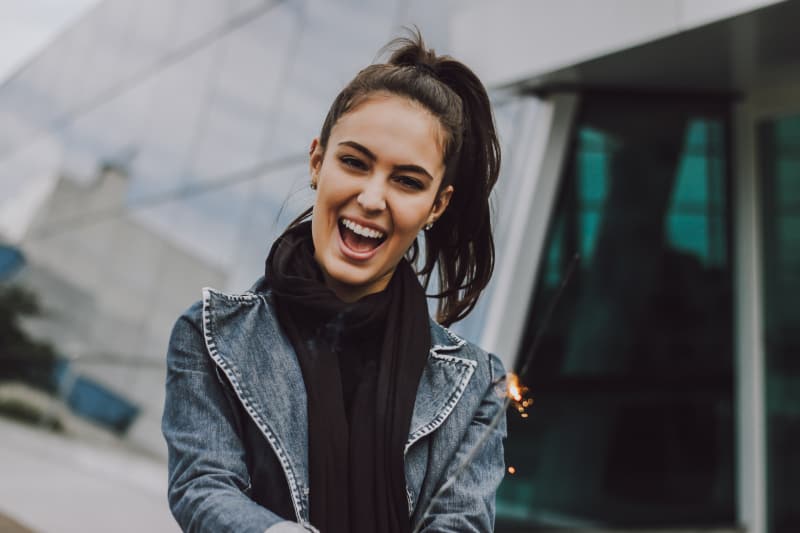 ein Mädchen in einer Jeansjacke freut sich