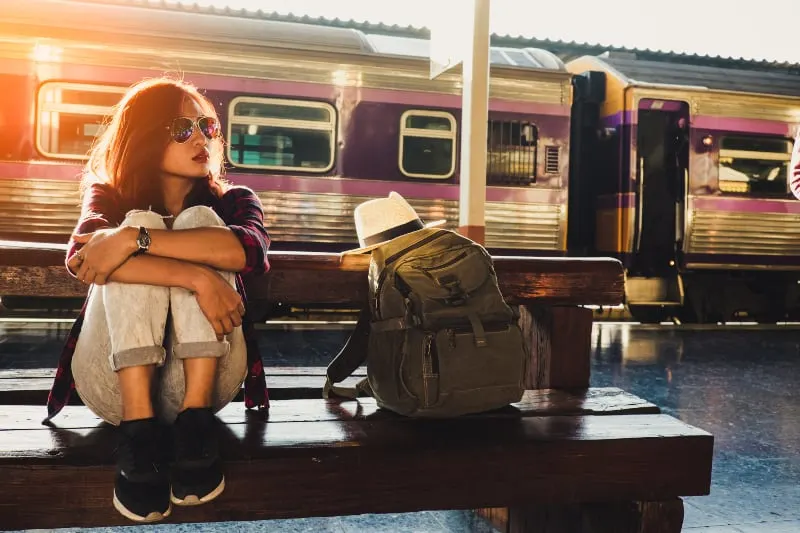 ein junges Mädchen wartet auf einen Zug