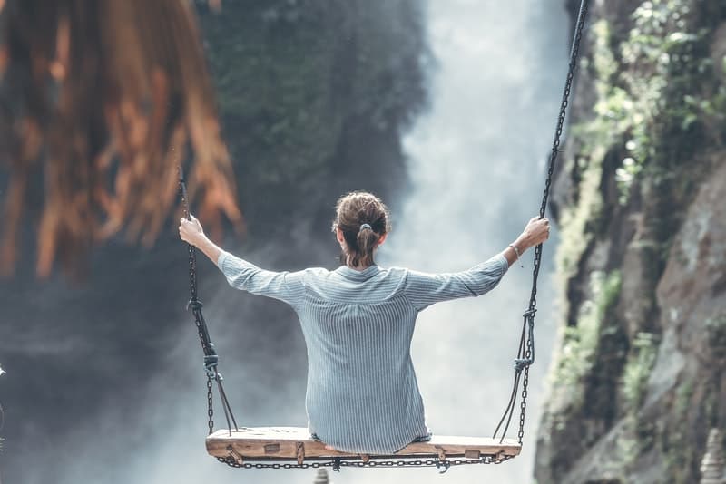 eine Frau auf einer Schaukel über dem Canyon