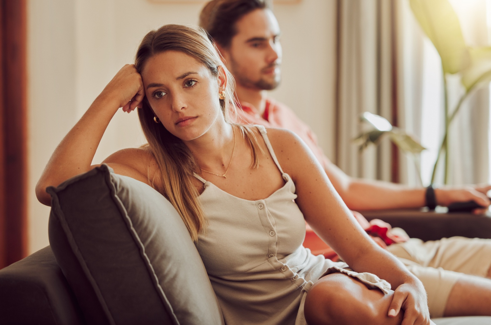 traurige Frau sitzt auf der Couch