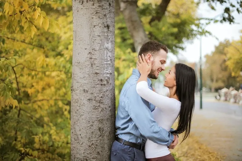 Ein Mann und eine Frau umarmen sich unter einem Baum
