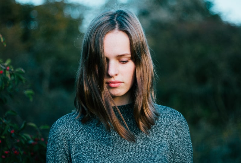 Frau trägt grauen Strickpullover