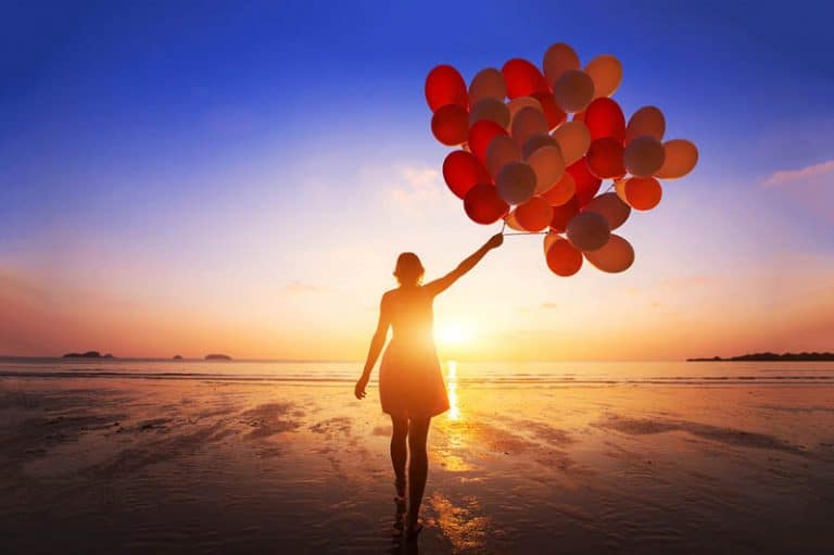 ein Mädchen, das Hunderte von Luftballons in der Hand hält