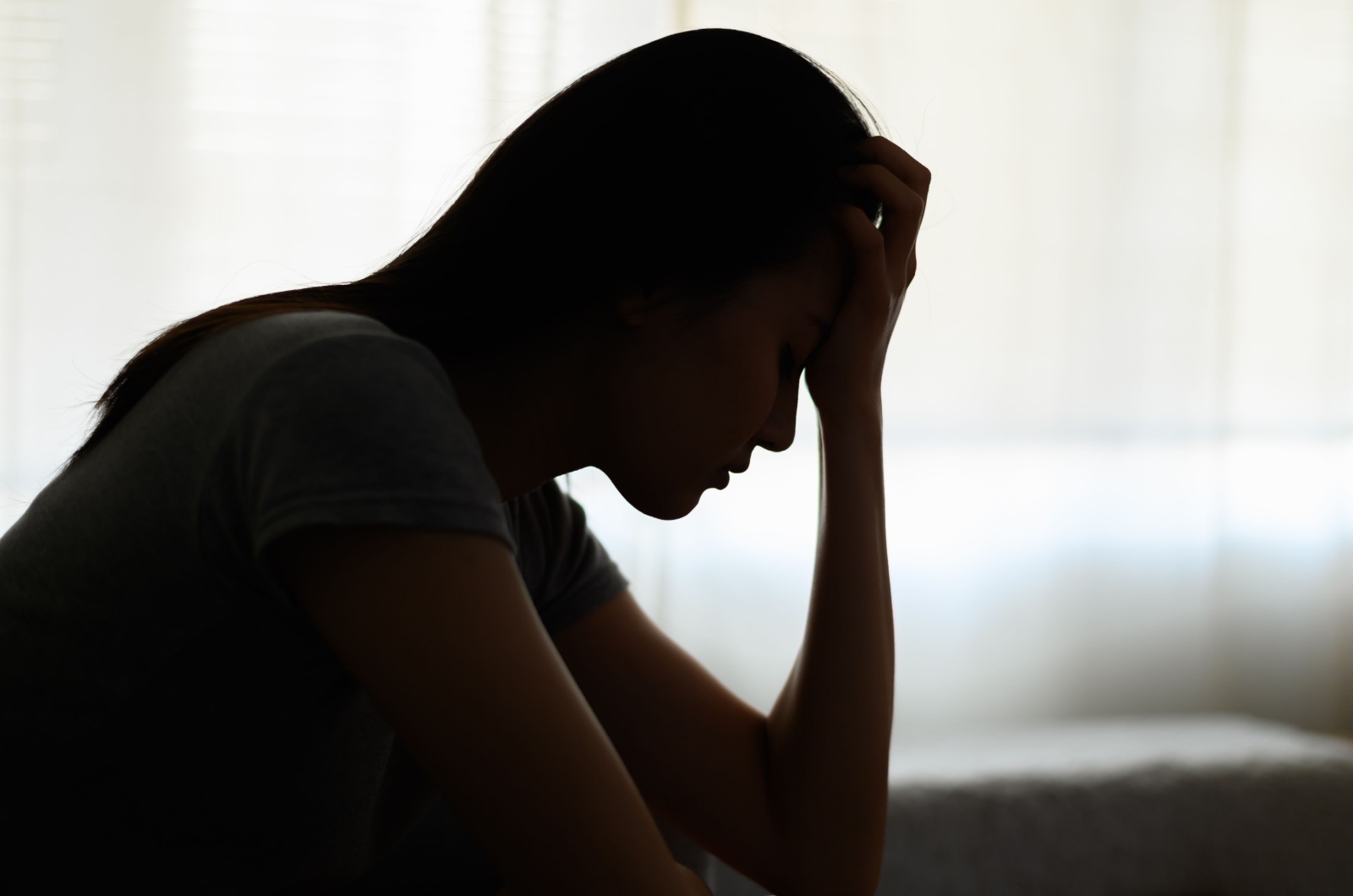 traurige und deprimierte Frau im Schlafzimmer