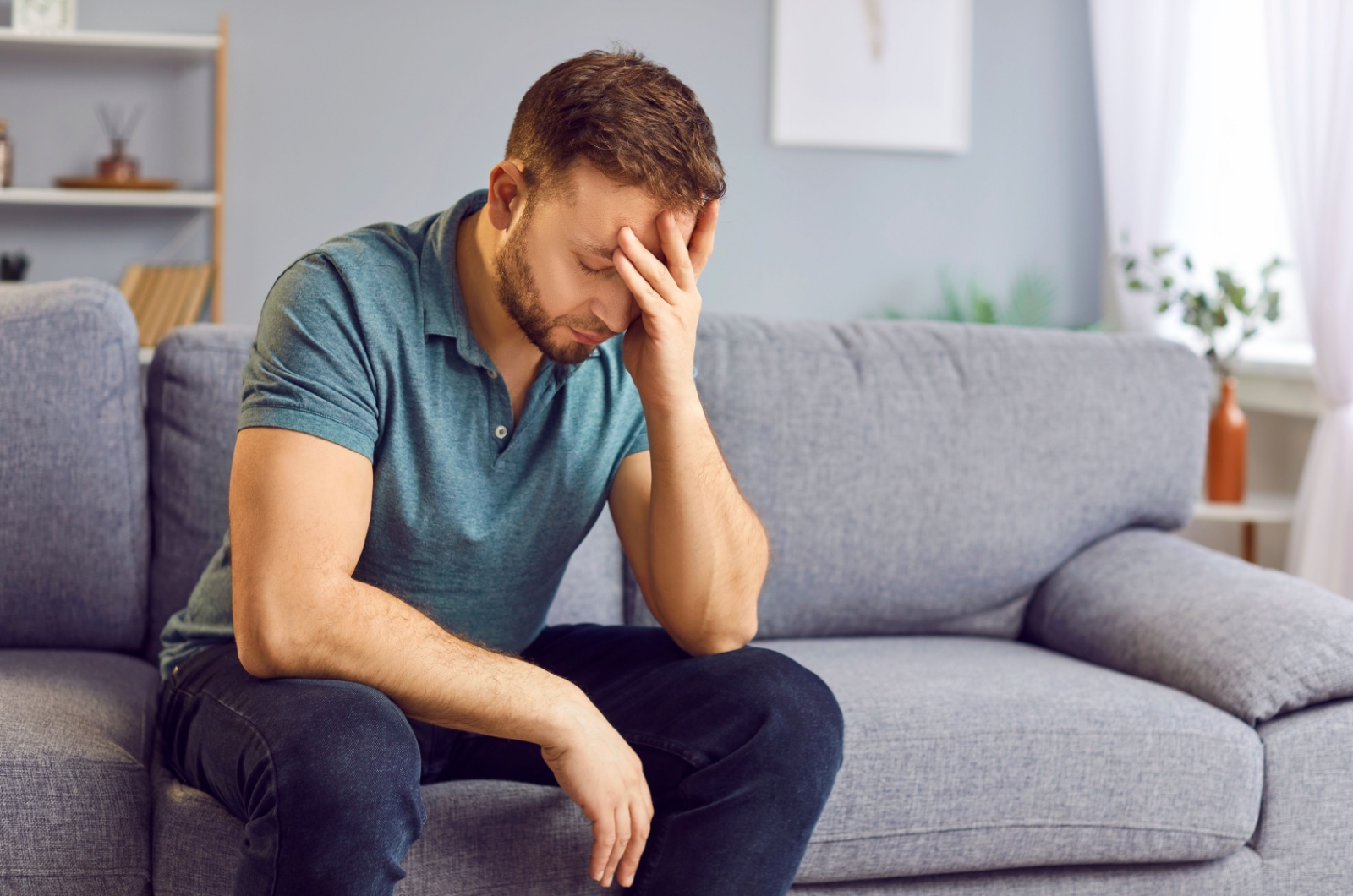 trauriger Mann sitzt auf der Couch