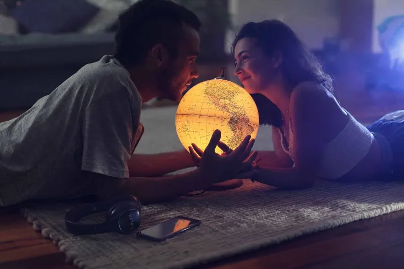 Ein Mann und ein Mädchen liegen auf dem Boden und halten einen Globus in den Händen(1)
