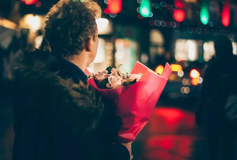 Ein Mann wartet auf ein Mädchen mit einem großen Blumenstrauß(1)