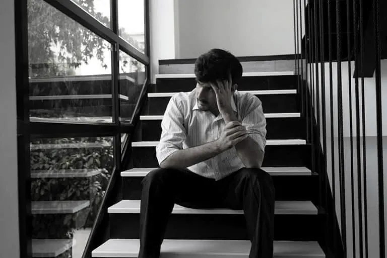 Ein trauriger Mann sitzt auf der Treppe