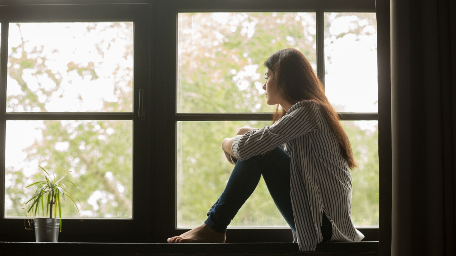 trauriges Maedchen am Fenster