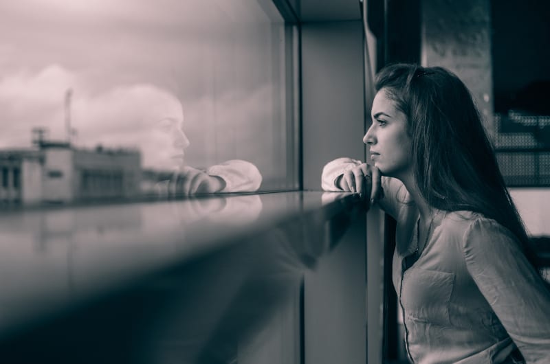 ein junges Mädchen, das das Spiegelbild ihres Charakters im Spiegel betrachtet